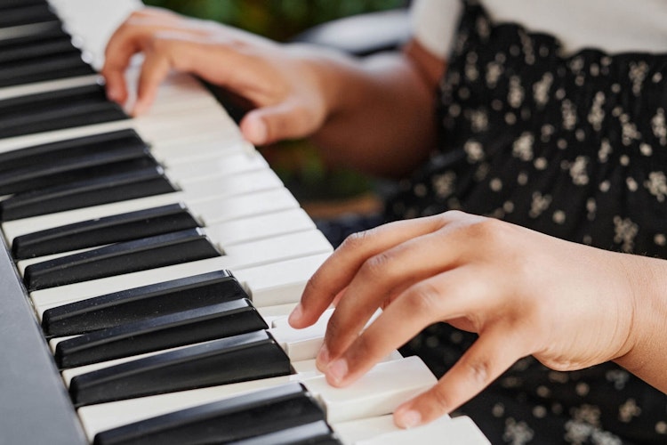 photo of young child playing keyboard