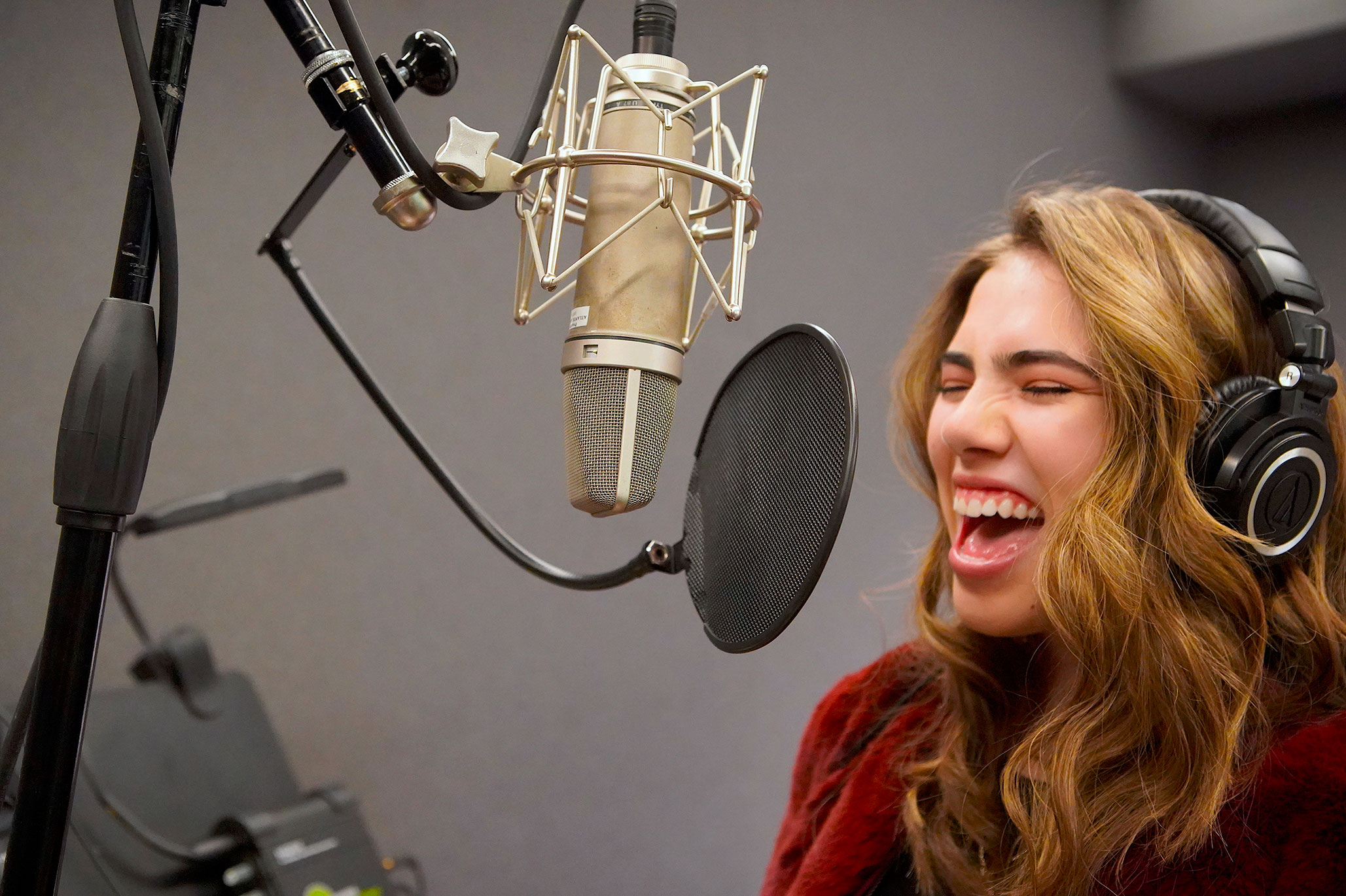 A School of Rock student singing in a recording studio