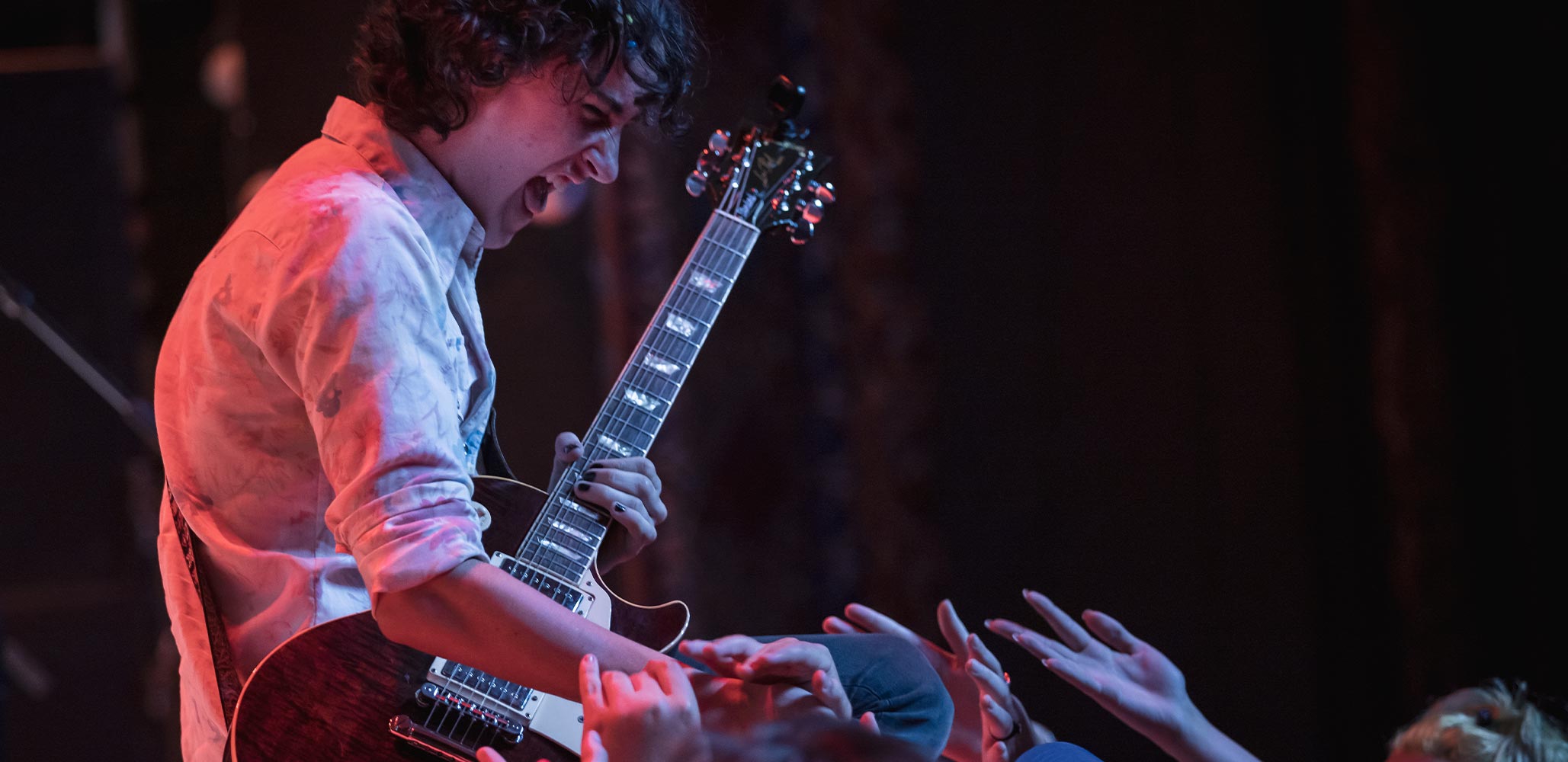 A School of Rock student confidently performing on stage